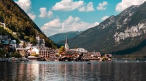 Explore the picturesque town of Hallstatt nestled by a tranquil lake, surrounded by vibrant summer landscapes and majestic mountains.