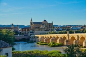 A bridge over a river with a castle in the background