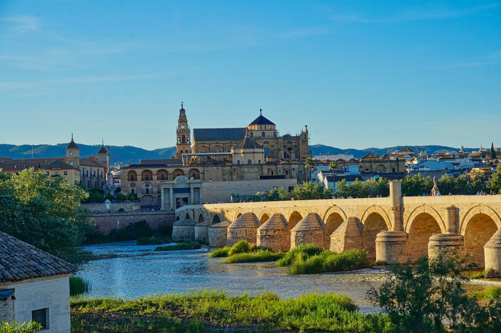 A bridge over a river with a castle in the background