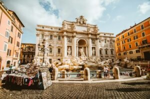 The Trevi Fountain with ornate sculptures in a sunlit square in Rome, Italy