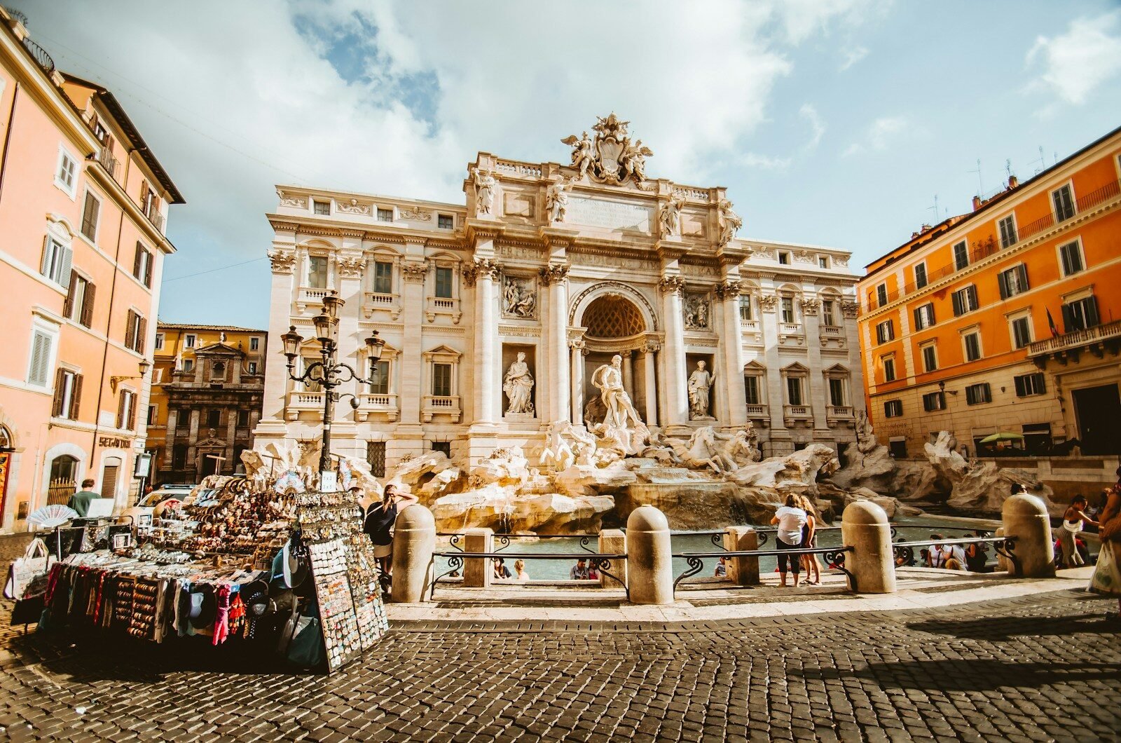 The Trevi Fountain with ornate sculptures in a sunlit square in Rome, Italy