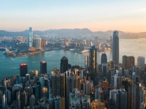 High-angle view of the Hong Kong skyline across Victoria Harbour in golden hour light