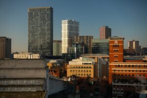 Tall modern buildings stand against a clear blue sky